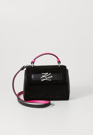 Sac à main noir avec des accents roses, tissu texturé, quincaillerie en argent, forme rectangulaire, et une bandoulière detachable.