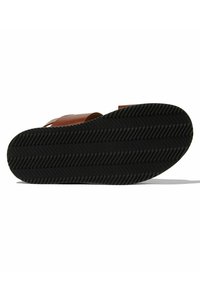 Smeđe kožne sandale s crnim gumenenim potplatom koji ima uzorak riblje kosti. Vidljiva konstrukcija trake i teksturirana podloga za bolji grip.
