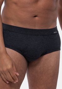 Schwarze gestreifte Slips mit weichem elastischen Bund. Die Stofftextur ist glatt, mit einer enganliegenden Passform und einem Frontbereich.