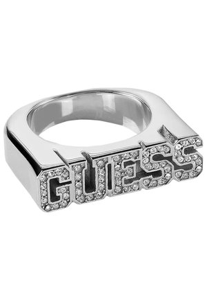 Bague ton argent avec une bande carrée portant le mot « GUESS » en lettres majuscules ornées de cristaux sur le dessus.