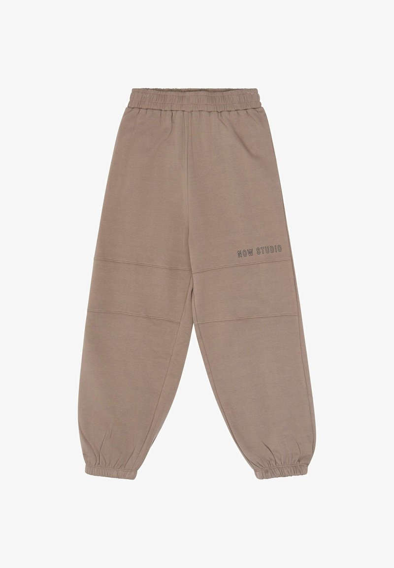 Pantalon de jogging taupe avec taille élastique et poignets froncés, avec le texte « NOW STUDIO » sur la partie supérieure de la jambe gauche, présenté sur fond blanc.