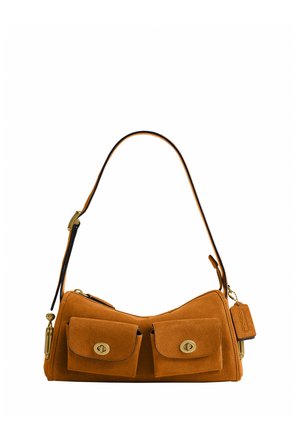 Sac à main en daim marron avec deux poches avant, fermoirs dorés, une bandoulière unique et une étiquette en cuir suspendue sur fond blanc.