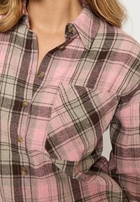 Rosa und braun kariertes Flanellhemd mit Knopfkragen, Knöpfen und Brusttasche, betont weiche Textur und klassisches Design.