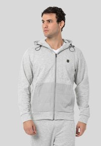 Hellgraue Zip-Up-Hoodie aus Baumwollmischung, mit einer gesteppten Fronttasche, verstellbarem Kapuzenkragen und einem dezenten Logo auf der Brust.