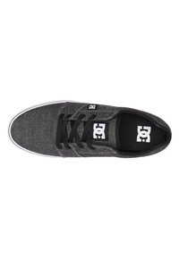 Zapatilla de tela gris con cordones negros, suela blanca y logotipo. Textura suave, diseño de corte bajo y plantilla acolchada para mayor comodidad.