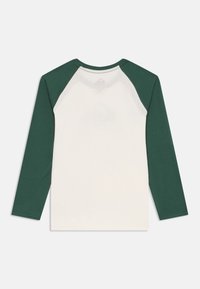 Long-sleeve shirt with white body and dark green raglan sleeves, made of soft cotton, featuring a rounded neckline and simple design.