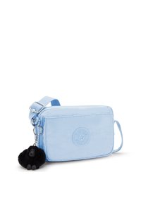 Borsa a tracolla di tessuto blu con una finitura testurizzata, dotata di un logo circolare in rilievo e un portachiavi di un gorilla nero peloso.