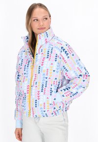 Jachetă căptușită cu o bază albastră, având un model cu inimioare multicolore în nuanțe de roz, galben și bleumarin. Include un guler înalt și închidere cu fermoar.