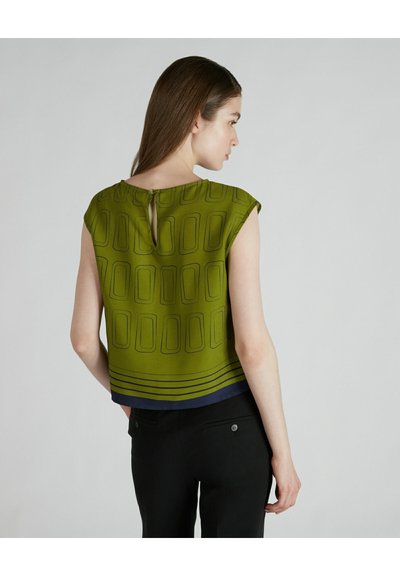 Blusa verde a maniche corte con motivo geometrico, caratterizzata da un dettaglio a chiave sulla schiena e strisce blu navy lungo l'orlo. Tessuto leggero.