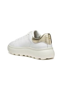 Baskets en cuir blanc avec une semelle épaisse et rembourrée. Présente un accent métallique doré au niveau du talon et des lacets à l'avant.
