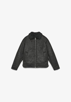 Veste en peau de mouton noir avec doublure, zip sur le devant, col distinctive, poches latérales doubles et tissu texturé. Elle possède une fermeture éclair et une sangle réglable.