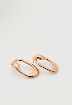 Een paar glanzende roségouden abstracte ovale creolen met onregelmatige, gladde vormen en steker-sluitingen op een witte achtergrond.