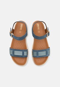 Paire de sandales marron avec des lanières bleues et des boucles couleur or, vues de dessus sur fond blanc.