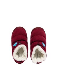 Pantuflas de corduroy rojo con forro blanco esponjoso, diseño acolchado y logo azul. Forma redondeada con suelas de goma para agarre.