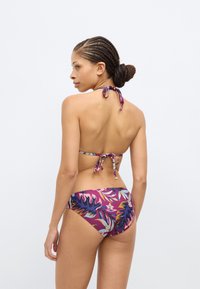 Σετ μπικίνι με πολύχρωμο ανθικό σχέδιο, δέσιμο στο λαιμό τύπου halter και σλιπ μπικίνι με χαμηλή μέση σε μωβ και ροζ αποχρώσεις.