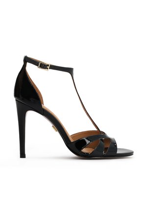 Schwarze Sandalen aus Lackleder mit hohen Absätzen, T-Riemen-Design, verstellbarer Schnalle am Knöchel und offenem Zehenbereich, mit sich kreuzenden Riemen.