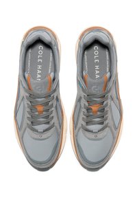 Sneaker grigi con materiali in rete e suede, caratterizzati da un accento in pelle beige, lacci tondi e una suola in gomma spessa.