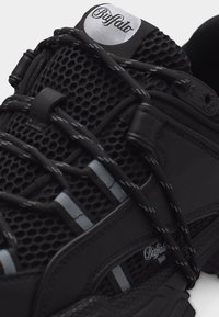 Αθλητικό παπούτσι Black Buffalo με υφαντό δίχτυ, κορδόνια με αντανακλαστικές ρίγες και πλακίδια λογότυπου στη γλώσσα και την πλαϊνή πλευρά.