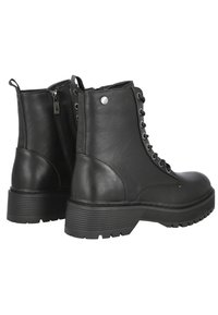 Botas de tobillo de cuero negro con punta redondeada, cordones en la parte delantera, detalle de cremallera y suela de goma texturizada con patrones de agarre. Acabado en plata en el lateral.
