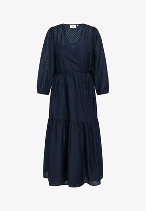 Navy zila garām piedurknēm wrap kleita, izgatavota no struktūras auduma, ar dziļu V-veida kakla izgriezumu, saistītu jostasvietu un pakāpenisku svārku, kas veido plūstošu siluetu.