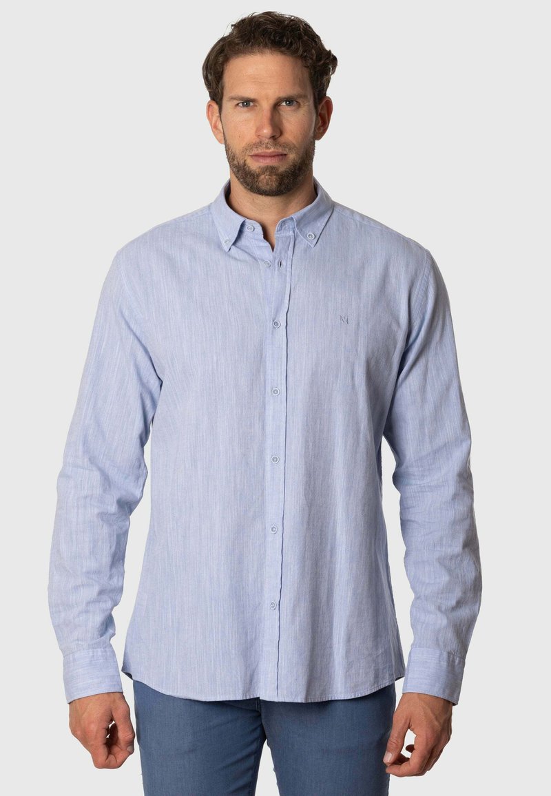 Camisa de botón azul claro con un tejido texturizado y mangas largas. Presenta un collar clásico y un sutil logo bordado en el pecho.