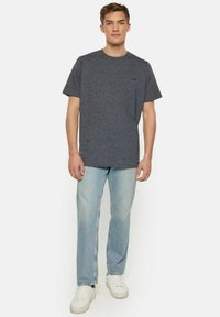 Szary heather z krótkim rękawem T-shirt z okrągłym dekoltem, połączony z jasnoniebieskimi prostymi jeansami i białymi trampkami. Minimalistyczny detal logo.