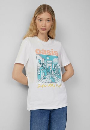 T-shirt en coton blanc avec un design illustré en bleu comportant des personnages et des objets, avec le texte "oasis" et "Definitely rock" en orange et jaune.