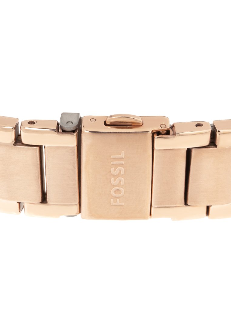 Correa de reloj Fossil en metal dorado rosa con eslabones entrelazados y un cierre que presenta el logo de la marca grabado. Acabado suave, diseño robusto.