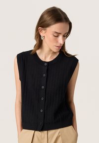 Zwarte gebreide mouwloze cardigan met verticale ribbelstructuur, vijf knopen aan de voorkant en een ronde halslijn.