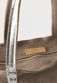 Καφέ τσάντα ώμου από καμβά με ασημί παγιέτες, διαθέτει φερμουάρ και δερμάτινη ετικέτα που αναγράφει «LE CABAS VANESSA BRUNO MADE IN FRANCE.»