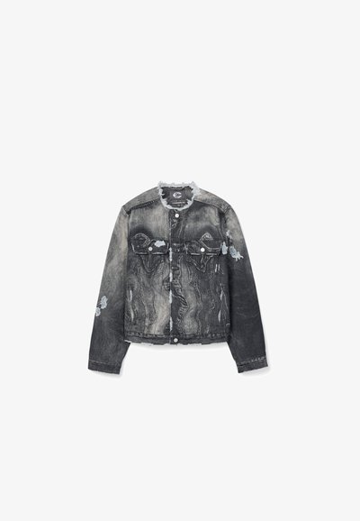 Veste en jean noire et grise délavée avec des détails usés, fermeture boutonnée, deux poches poitrine et bords de col effilochés.