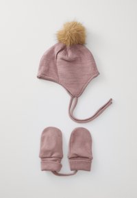 Rosa gestrickte Babymütze mit einem braunen Kunstfell-Pompon obendrauf, kombiniert mit passenden rosa Fäustlingen. Beide bestehen aus weichem, strukturiertem Stoff.