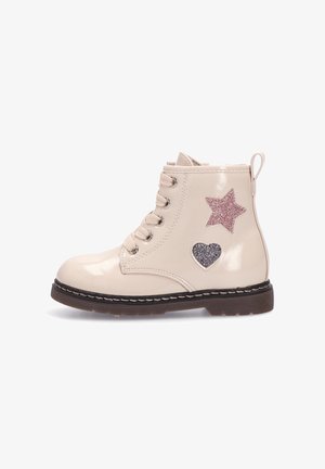 Botines con cordones en brillante cuero sintético beige, con apliques de estrella rosa y corazón plateado, suela marrón texturizada y tirador.