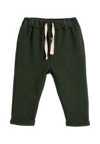 Pantalones de chándal para niño en verde oscuro con cintura elástica, bolsillos frontales, cordones beige y puños doblados.