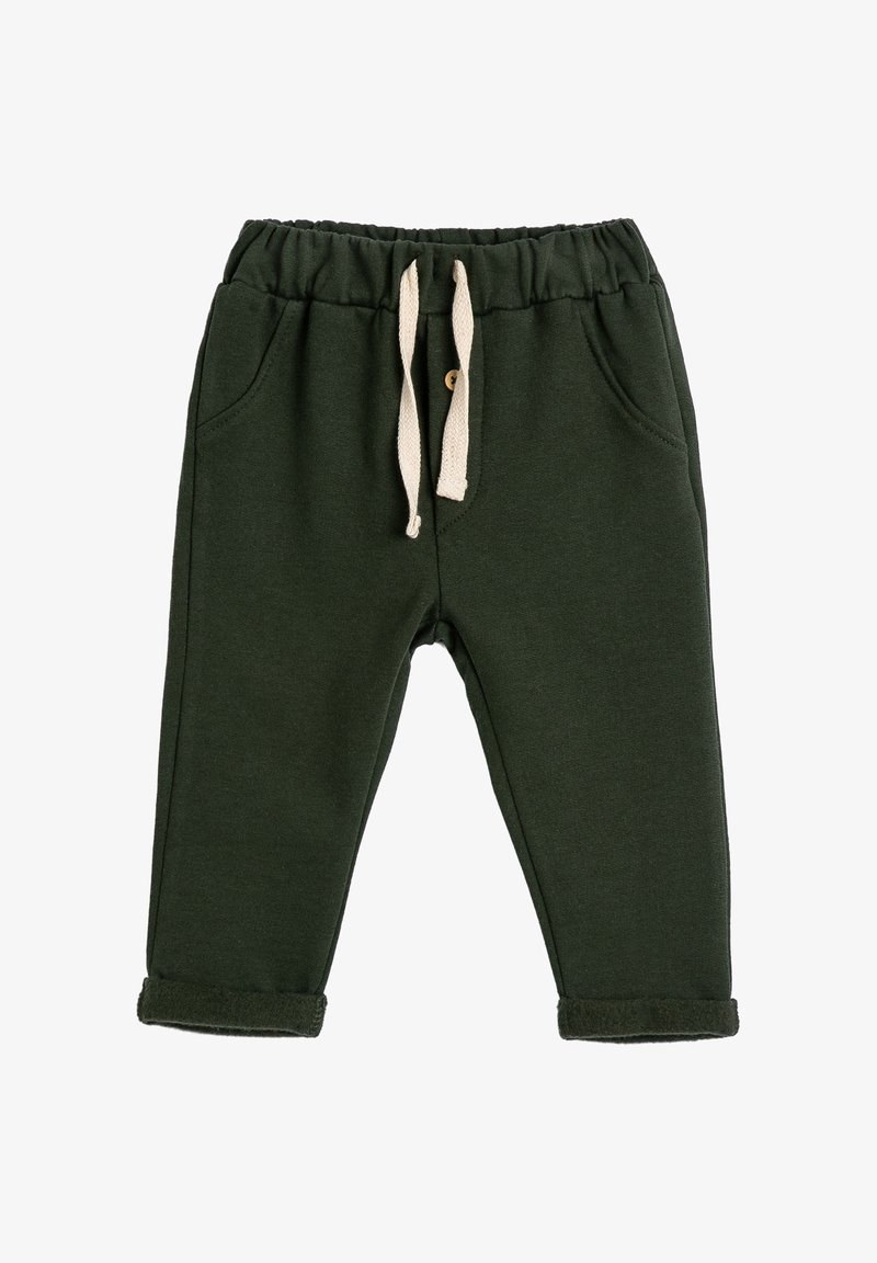 Pantalones de chándal para niño en verde oscuro con cintura elástica, bolsillos frontales, cordones beige y puños doblados.
