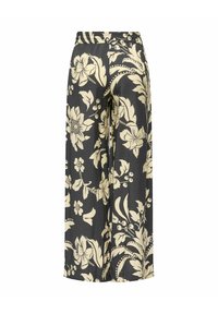 Zwarte broek met wijd uitlopende pijpen, beige grote bloemen- en bladpatronen en een elastische tailleband.