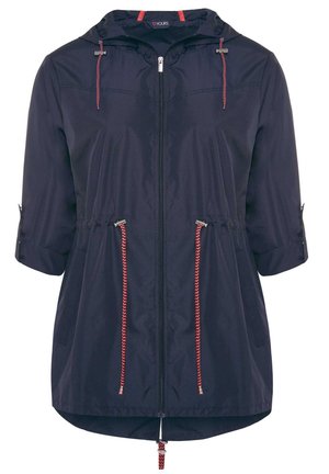Granatowa, lekka kurtka z kapturem i rękawami 3/4. Posiada czerwone sznurki i zamki błyskawiczne oraz lekko zaokrąglony dół.
