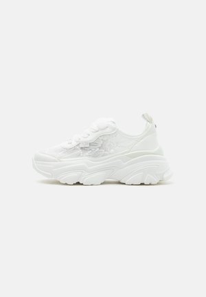 Witte chunky sneaker met veterluiting aan de voorkant, zijpanelen van mesh met bloemenprint, en dikke gevormde zool, weergegeven vanaf de linkerkant tegen een effen achtergrond.