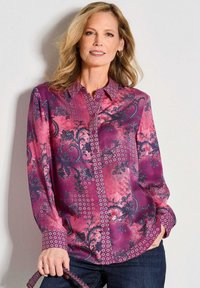 Langärmliges Hemd in Pink mit aufwendigen dunklen Blumen- und Diamantmustern, ausgestattet mit einem Kragen und einer durchgehenden Knopfleiste. Glatte Stofftextur.