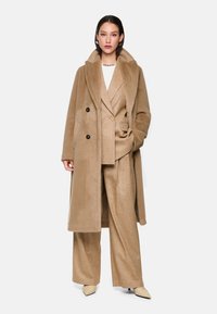 Beige wollen blend jas met grote kraag, dubbelzijdige voorkant, gecombineerd met metallic gouden pak en puntige beige schoenen. Gladde textuur, op maat gemaakte pasvorm.