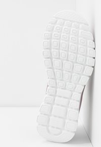 Biała podeszwa sneakersów z teksturowanym uchwytem, z prostokątnymi i kwadratowymi wzorami. Posiada gładką, lekko wygiętą część piętową.