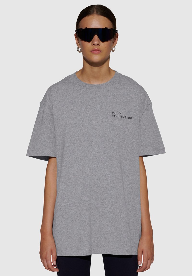 Grijze oversized t-shirt met korte mouwen, ronde hals, met een zwarte opdruk die "HALO 196819721981" op de linkerborst leest.