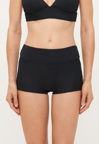 Bas de bikini noir à côtes avec une taille haute. Comprend une large ceinture élastique et une texture lisse. Convient pour les maillots de bain.