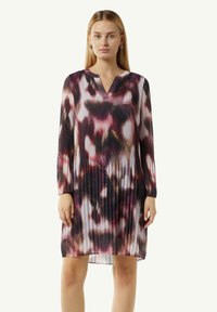 Blumiges, plissiertes Kleid in Schwarz, Pink und Lila. Hat einen V-Ausschnitt und lange Ärmel mit elastischen Bündchen. Seidige Textur.