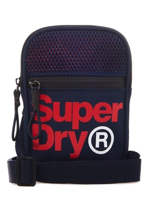 Marineblå crossbody taske med rød "Super Dry®" tekst, mesh topsektion, sort lynlås, dobbelte sorte lynlåstræk og justerbar rem.