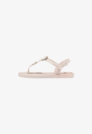 Sandalo flat rosa chiaro con cinturino tra le dita, cinturino regolabile alla caviglia e dettagli con perline metalliche lungo la cinghia superiore.