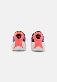 Puma sneakers met een zwart en roze mesh bovenwerk, felle oranje hielcounter en witte, gestructureerde zool, met logo-detail op de hiel.