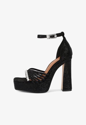 Sandalo nero con plateau e tacco alto, con cinturino alla caviglia, decorato con piccoli strass neri e fibbia argento.