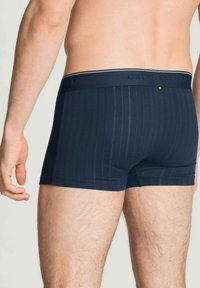 Navyblauwe boxers gemaakt van zachte stof met een verticale streeppatroon, voorzien van een brede elastische tailleband met het merklogo.