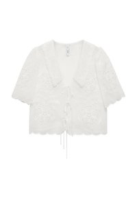 Blouse blanche à manches courtes avec des motifs floraux brodés. Elle présente un ourlet festonné et une fermeture à nouer à l'avant. Fabriquée en tissu léger.